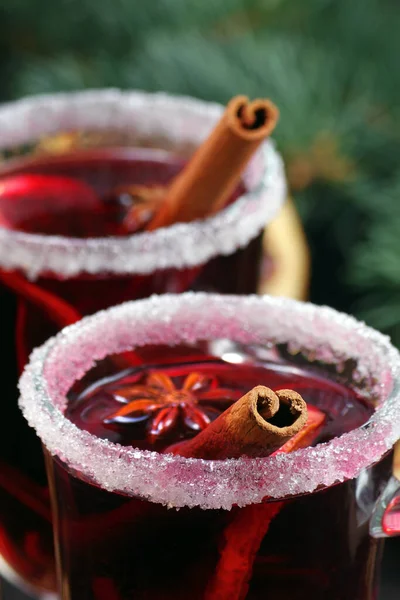 cups of mulled wine, spices and dry citrus fruits on a wooden table. warming christmas drink