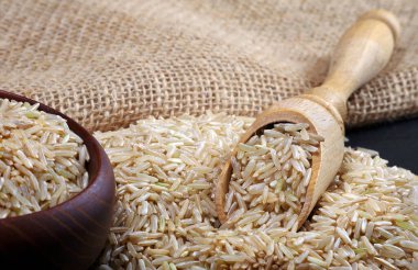 Masadaki kepçe içinde esmer pirinç. Kapat.