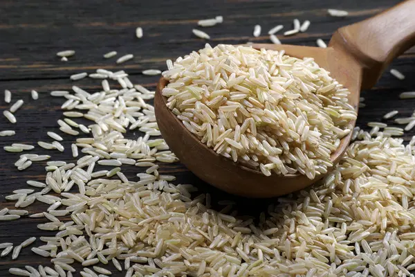 Masadaki kepçe içinde esmer pirinç. Kapat.