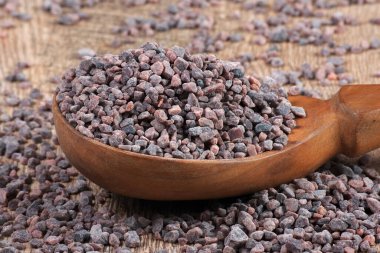 Masadaki tahta kaşıkta siyah Himalaya tuzu.