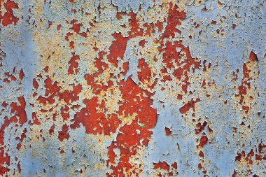 Eski paslı, boyanmış metal levha yakın plan.