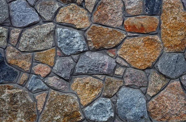 stone wall. wall of granite blocks. a masonry wall of multicolored stones or blocks close up