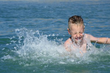 Çocuk denizde banyo yapıyor. su oyunları