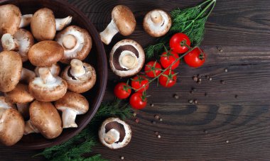 Tahta bir masada taze mantar şampiyonları, domatesler ve baharatlar. Üst Manzara. Boşluğu kopyala