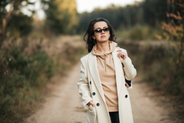 Orman yolunda güneş gözlüklü esmer kızın portresi.