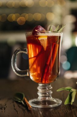 Alkollü. Kış ya da sonbahar için sıcak içecek. Limon, üzüm, tarçın ve karanfilli baharatlı çay ve rom kokteyli..