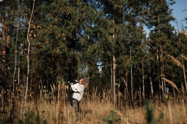 Mutlu kadın sonbahar ormanlarında siyah beyaz sınır köpeğiyle oynuyor.