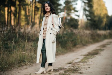 Orman yolunda sırt çantalı esmer kız.