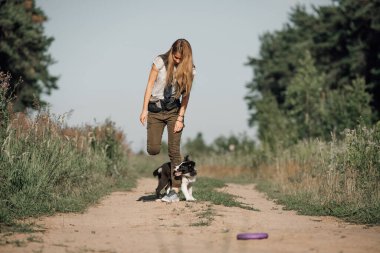 Siyah-beyaz sınırda çoban köpeği eğiten bir kız.