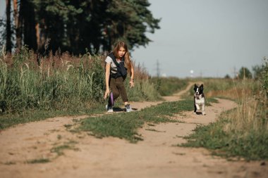 Siyah-beyaz sınırda çoban köpeği eğiten bir kız.