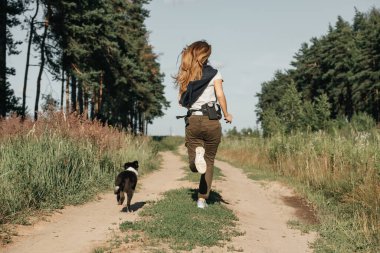 Siyah-beyaz sınırda çoban köpeği eğiten bir kız.