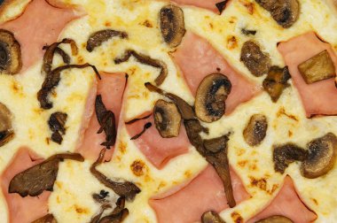 Siyah arka planda tahta bir tahtada jambonlu ve mantarlı pizza.