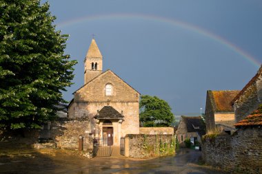 Church with a rainbow of Taize ,Burgundy. clipart