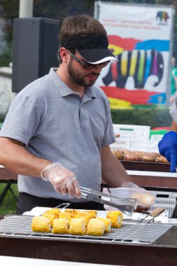 Bir adam bir ızgara üzerinde bir Mısır hazırlar 