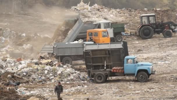 Garbage trucks unload garbage on a dump — Stock Video