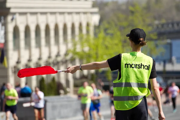 Volunteer Marshal shows the direction of runners — Stock Photo, Image