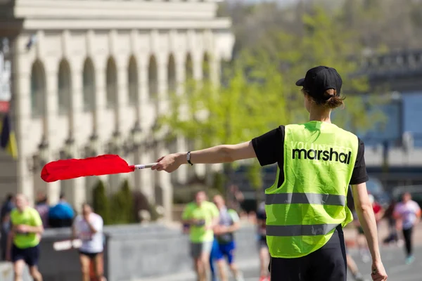 Le maréchal volontaire montre la direction des coureurs Image En Vente