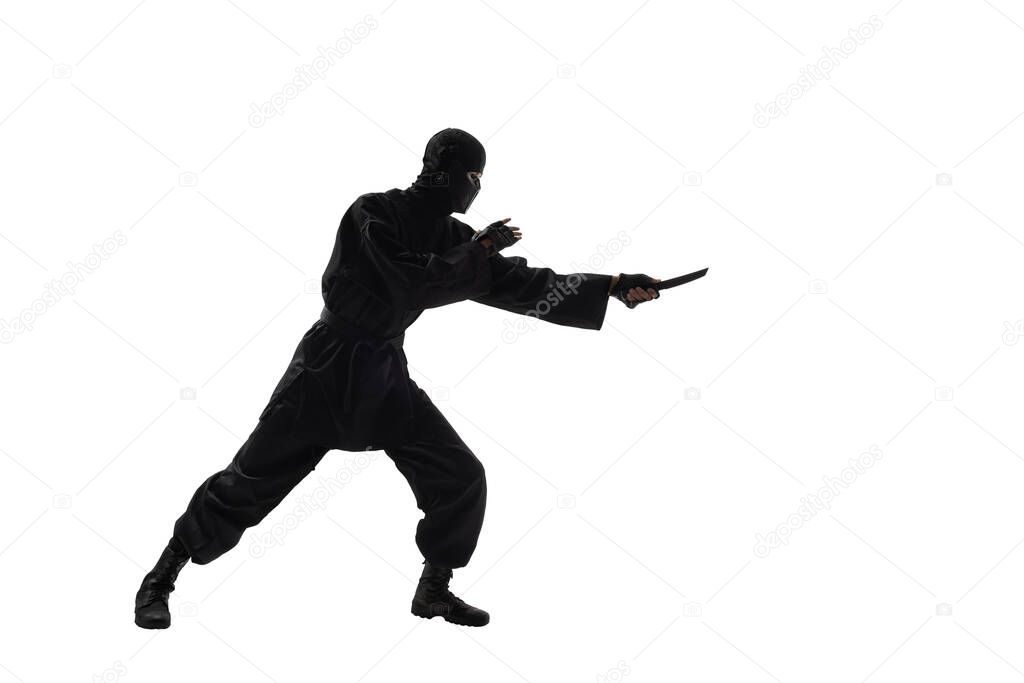one japanese ninja or assassin in black uniform with knife, on white background, isolated