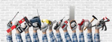 Bir grup el, ahşap işçiliği ve mobilya montajı ve inşaat veya onarım için beyaz tuğla duvar arka planında bir inşaat aracı tutuyor