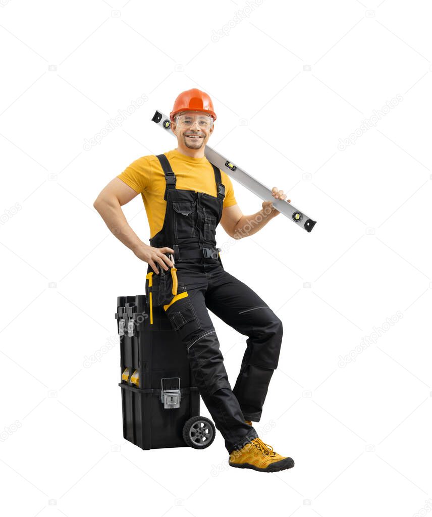 happy worker repairman - builder with construction tools in big tool-box, full body in black - yellow uniform and smile on white background, isolated. Repair service and construction concept