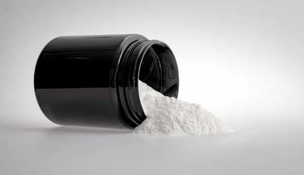 运动营养 蛋白质 用白色底色的黑色罐子测量勺子和白色药粉 营养补充剂或药物 药物治疗概念 — 图库照片