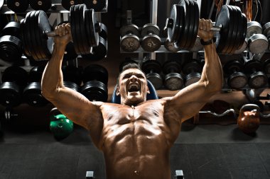 vücut geliştirmeci dumbbells ile