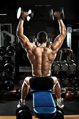 vücut geliştirmeci dumbbells ile