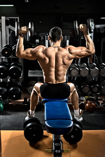 vücut geliştirmeci dumbbells ile