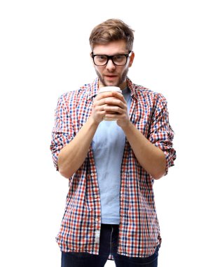 Kahve fincanı tutarak ve beyaz arka plan karşı dururken gülümseyen yakışıklı delikanlı