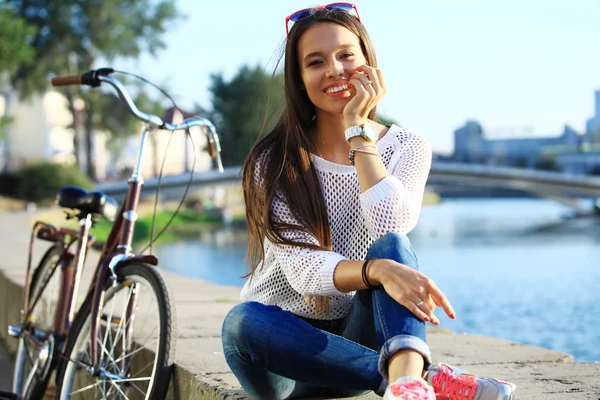 Jovem mulher e bicicleta na cidade — Fotografia de Stock