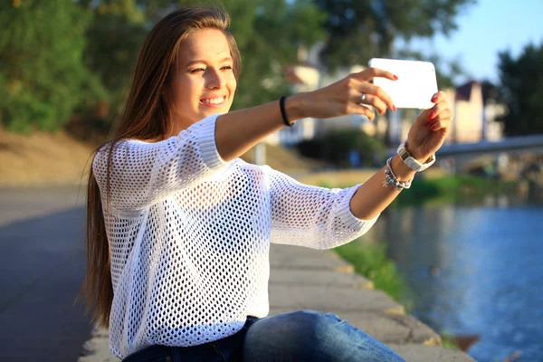 Hermosa joven selfie mujer en el parque con un teléfono inteligente —  Fotos de Stock