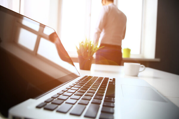 Рабочее место с ноутбуком и смартфоном на столе
