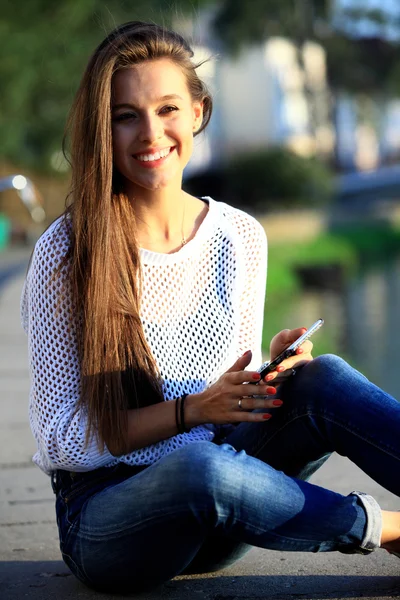 Retrato de una joven y bella mujer sonriente. Retrato de cerca de una joven y hermosa modelo posando al aire libre . — Foto de Stock