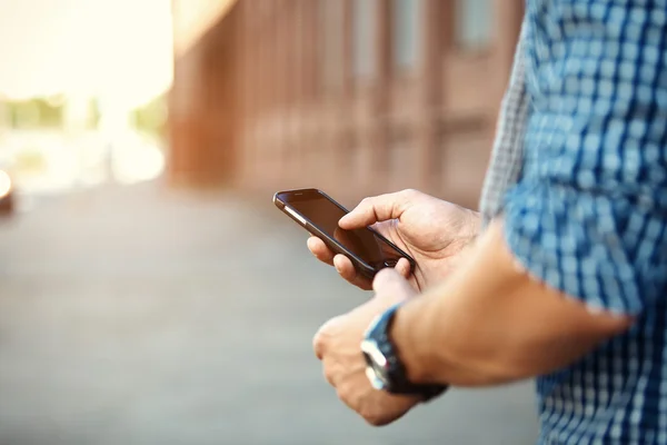 Primer plano del hombre que utiliza el teléfono inteligente móvil — Foto de Stock