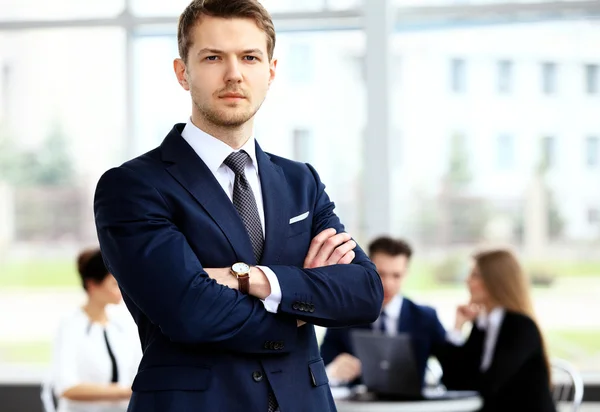 Zakenman met collega's op achtergrond — Stockfoto