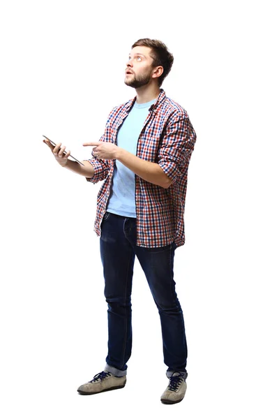 Улыбающийся молодой человек с помощью планшетного компьютера на белом фоне — стоковое фото