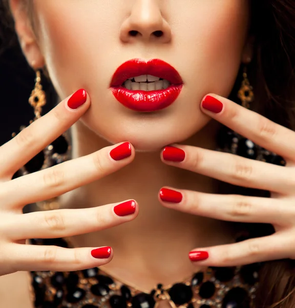 Labbra e Unghie Sexy Rosse primo piano. Manicure e trucco. Idea inventata. Metà del modello di bellezza ragazze faccia isolata su sfondo nero — Foto Stock