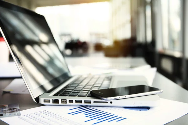 Kantoor werkplek met laptop op tafel tegen de ramen. — Stockfoto