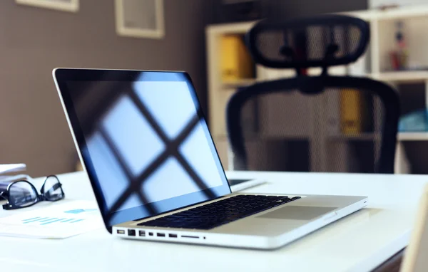 Irodai munkahely laptoppal a fa asztalon az ablakokkal szemben — Stock Fotó