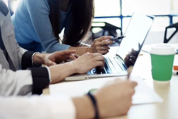 Equipo de jóvenes empresarios que trabajan con el nuevo proyecto de puesta en marcha en loft moderno. Teléfono inteligente de diseño genérico que sostiene las manos femeninas . —  Fotos de Stock