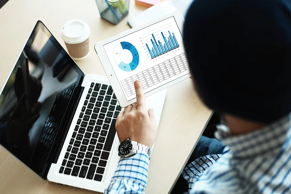 Business adviseur financiële cijfers ter aanduiding van de voortgang van het werk van bedrijf analyseren — Stockfoto