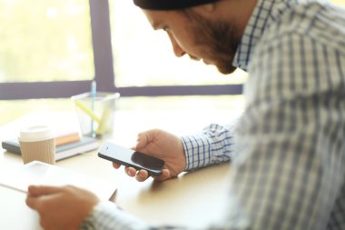 Modern cihazlar, dijital tablet bilgisayar ve cep telefonuyla çalışan genç işadamı