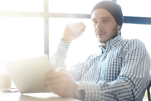 Knappe man die werkt vanuit zijn kantoor aan huis. Het analyseren van businessplannen op laptop. Onscherpe achtergrond, film effect — Stockfoto