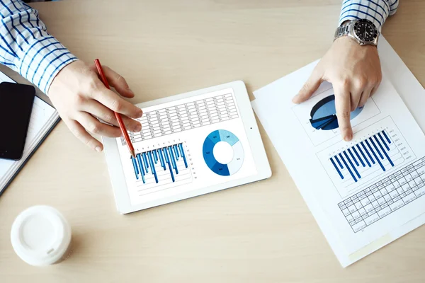 Business adviseur financiële cijfers ter aanduiding van de voortgang van het werk van bedrijf analyseren — Stockfoto