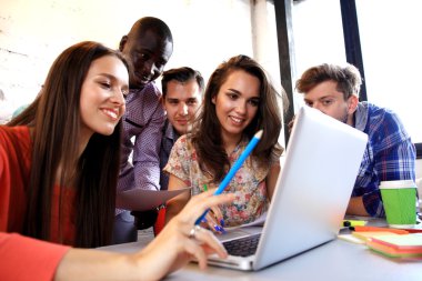Harika kararlar verirken. Genç güzel kadın gesturing ve onun iş arkadaşları onu ofis masasında otururken dinlerken gülümseme ile bir şey tartışıyor