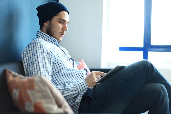 Um homem bonito a trabalhar no escritório dele. Analise os planos de negócios no laptop. Fundo desfocado, efeito filme — Fotografia de Stock