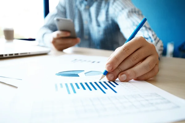 Asesor de negocios analizando cifras financieras que denotan el progreso en el trabajo de la empresa — Foto de Stock