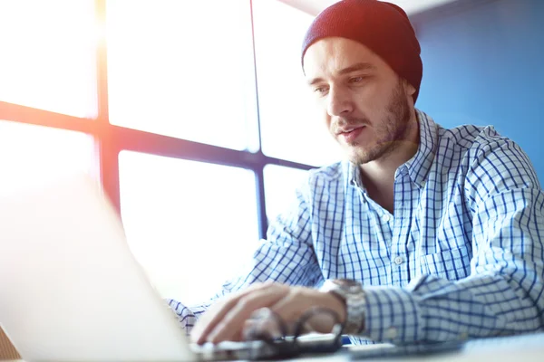 Pria tampan yang bekerja di kantor rumahnya. Menganalisa rencana bisnis pada laptop. Latar belakang kabur, efek film — Stok Foto