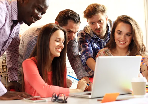 Het nemen van goede beslissingen. Jonge mooie vrouw gebaren en bespreken van iets met glimlach terwijl haar collega's luisteren naar haar zittend op kantoor tafel — Stockfoto