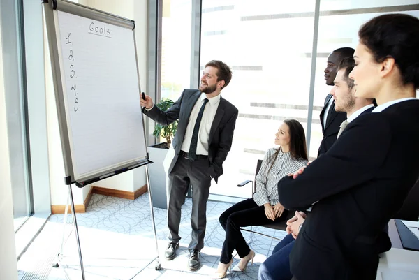 Vrolijke zakenman nieuw zakelijk project bespreken met de leden van zijn team — Stockfoto